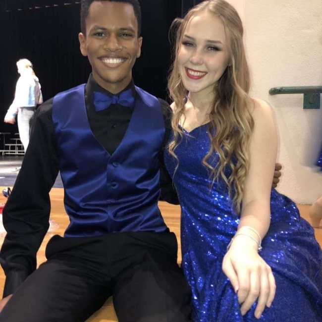 C.j112 as seen while smiling for a picture alongside Riley Becca in December 2019
