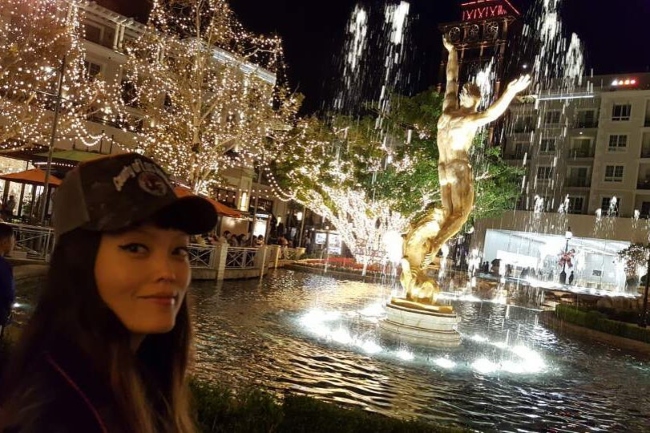Hana Mae Lee in a selfie with a dazzling backdrop
